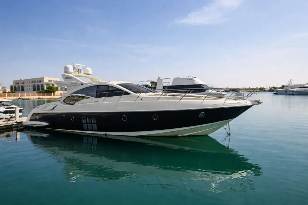 The 68 Ft Super Yacht with a dark hull moored at a marina in Abu Dhabi under a clear blue sky